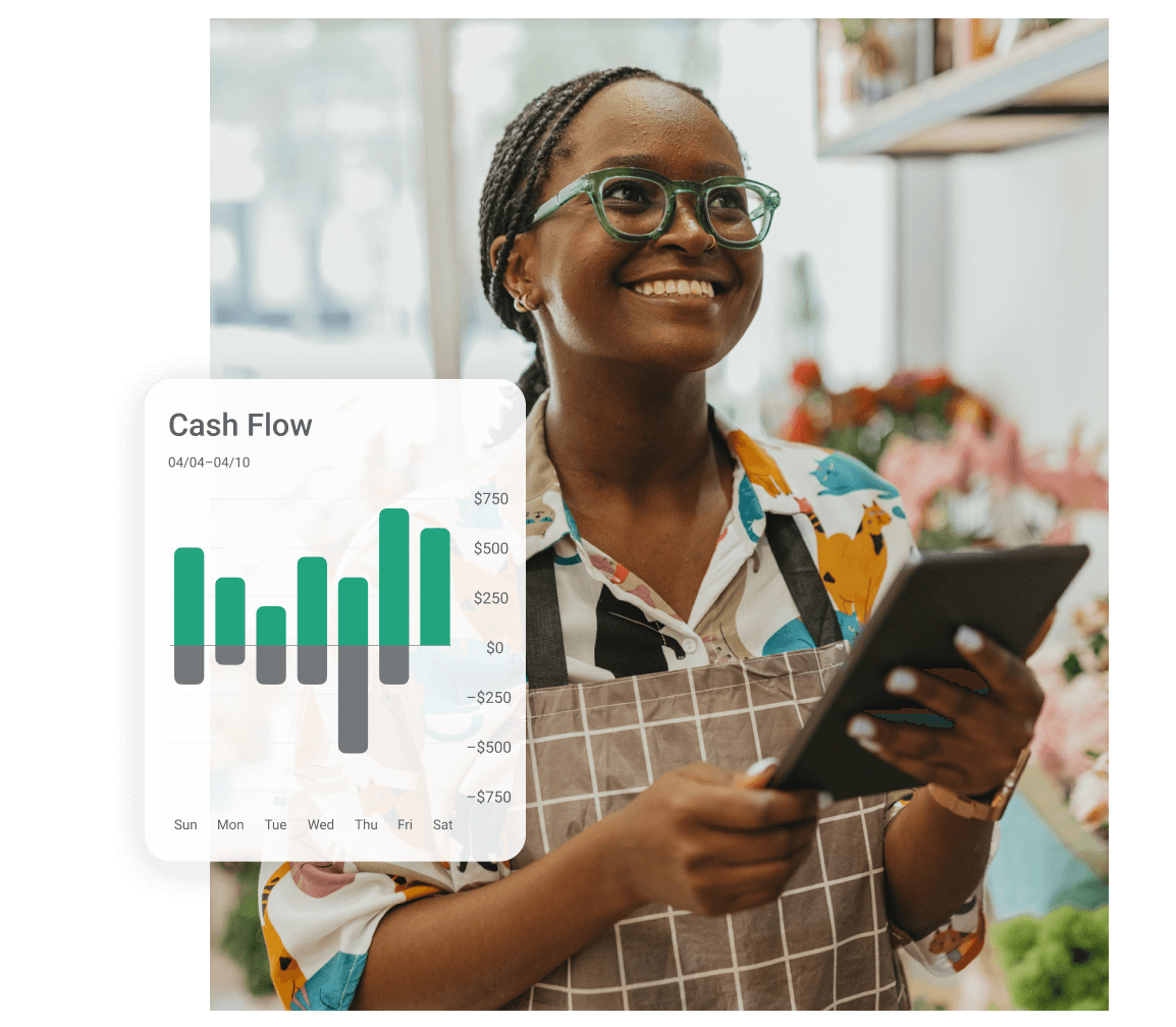 Young woman wearing classes and an apron smiling while holding a tablet inside a flower store. A cash flow screen capture from the Pillur app is displayed on the left.